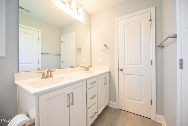 bathroom with tile patterned flooring and dual bowl vanity