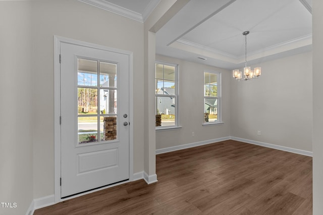 entryway featuring a notable chandelier, dark hardwood / wood-style floors, crown molding, and a tray ceiling