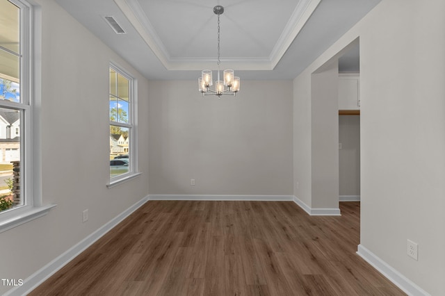 unfurnished room with dark hardwood / wood-style floors, a wealth of natural light, and a tray ceiling