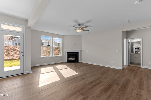 unfurnished living room featuring dark hardwood / wood-style floors and ceiling fan