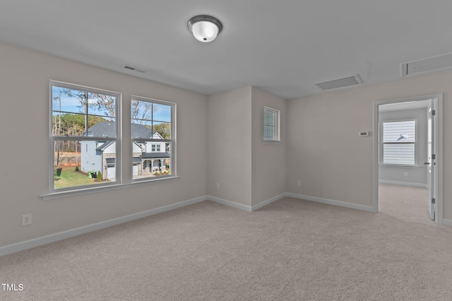 unfurnished room featuring light carpet