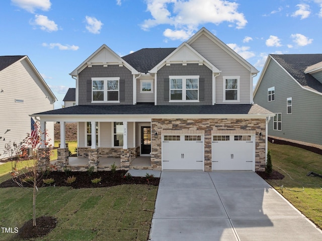 craftsman house with covered porch, a garage, and a front lawn