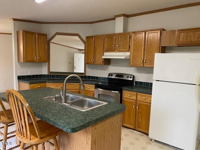 kitchen with white refrigerator, a textured ceiling, sink, stainless steel electric range oven, and a kitchen breakfast bar