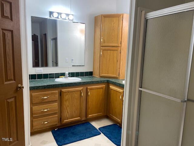 bathroom featuring walk in shower and vanity