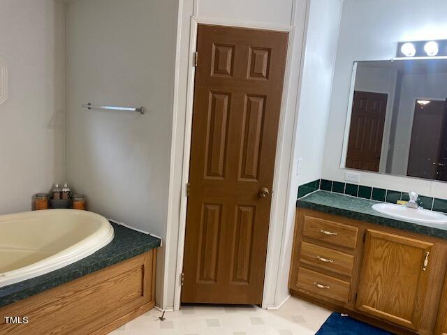 bathroom featuring vanity and a washtub