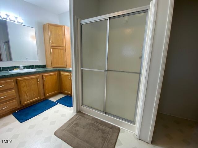 bathroom featuring vanity and an enclosed shower