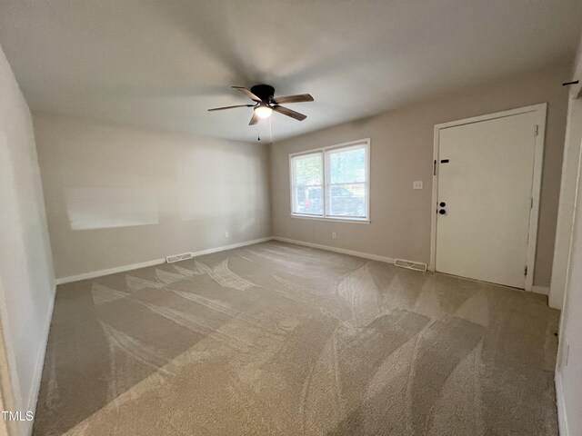 carpeted spare room featuring ceiling fan