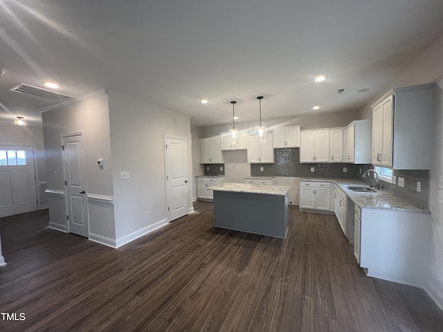 kitchen with dark hardwood / wood-style floors, white cabinetry, sink, hanging light fixtures, and a center island