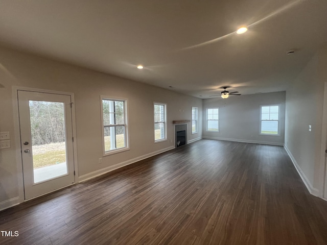 unfurnished living room with dark wood-type flooring and ceiling fan