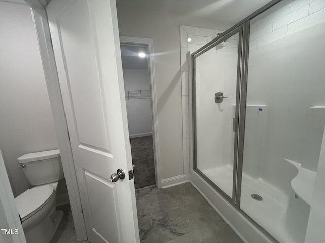 bathroom with toilet and a shower with shower door