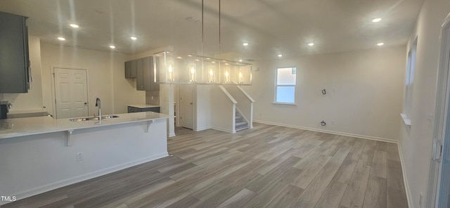 kitchen featuring a peninsula, light wood finished floors, and recessed lighting