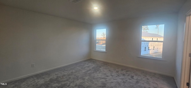 spare room featuring visible vents, baseboards, and carpet flooring