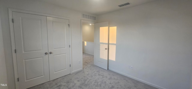 unfurnished bedroom featuring a closet, visible vents, baseboards, and carpet flooring