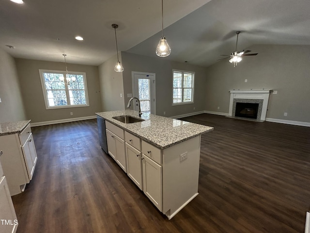 kitchen with white cabinetry, dark wood-style flooring, a sink, and a high end fireplace