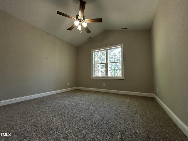 carpeted empty room with visible vents, vaulted ceiling, baseboards, and ceiling fan