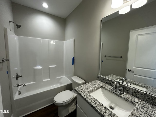 full bathroom with wood finished floors, bathing tub / shower combination, vanity, and toilet