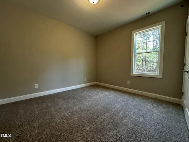 carpeted spare room featuring baseboards and visible vents