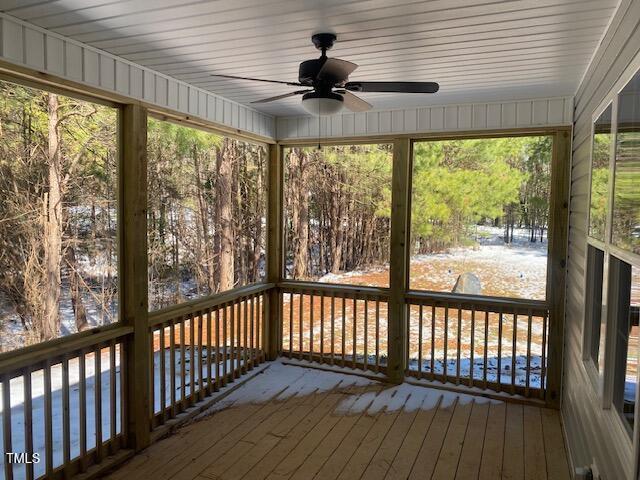 unfurnished sunroom featuring ceiling fan