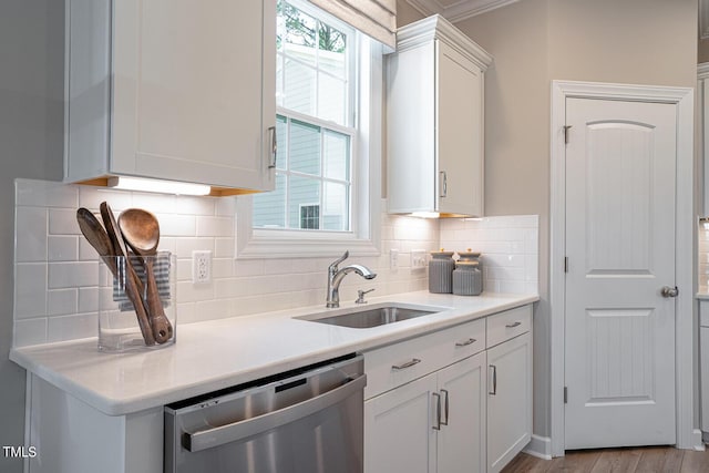 kitchen with a sink, white cabinets, light countertops, a wealth of natural light, and dishwasher