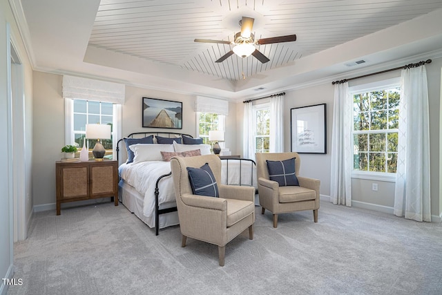 bedroom featuring crown molding, a raised ceiling, light colored carpet, visible vents, and baseboards