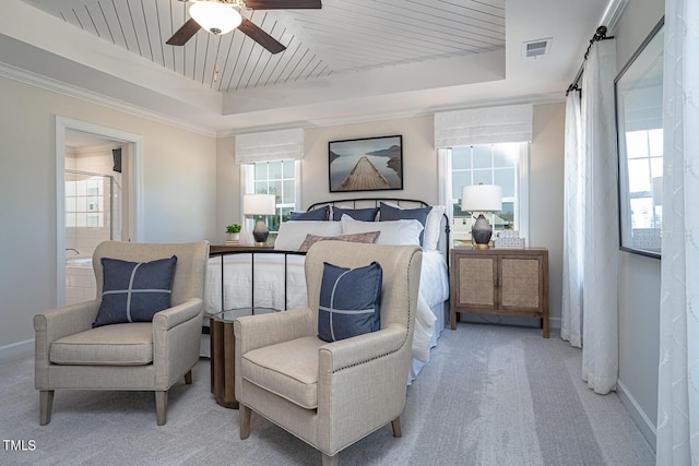 bedroom featuring a tray ceiling, a barn door, visible vents, and light colored carpet