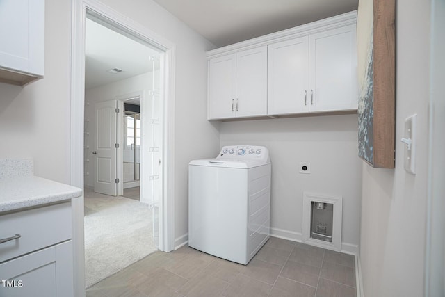 washroom featuring light carpet, washer / clothes dryer, cabinet space, and baseboards