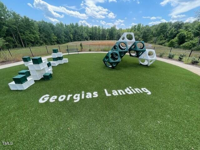 view of play area featuring a lawn and fence