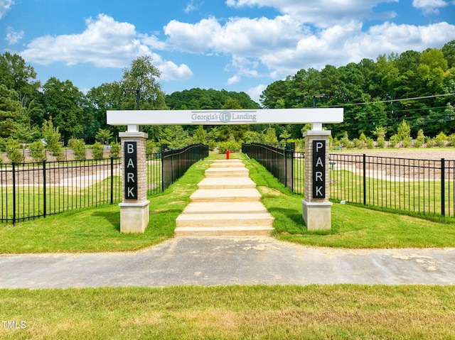 view of property's community with a yard and fence