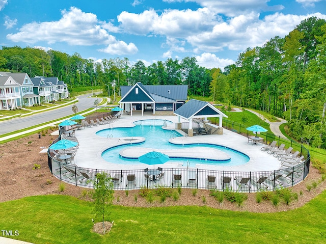 community pool featuring fence, a lawn, and a gazebo