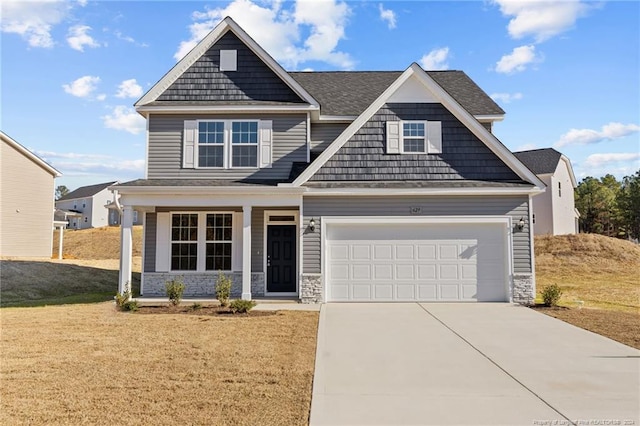 craftsman house featuring a porch, a garage, and a front yard