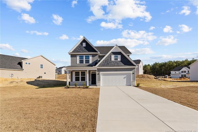 craftsman-style home featuring covered porch, a garage, and a front lawn