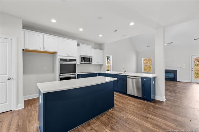 kitchen featuring blue cabinets, white cabinets, dark wood-type flooring, and appliances with stainless steel finishes