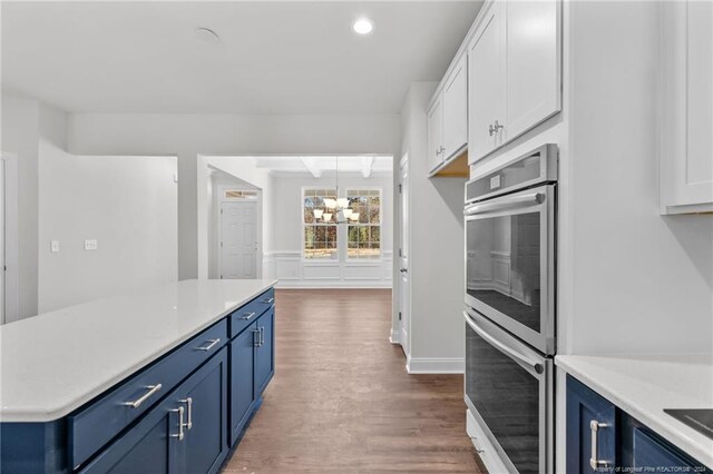 kitchen with hanging light fixtures, blue cabinetry, a notable chandelier, dark hardwood / wood-style flooring, and white cabinetry