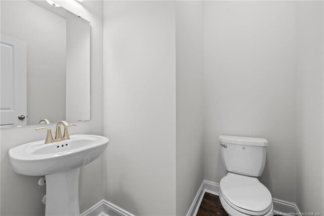 bathroom featuring sink, wood-type flooring, and toilet