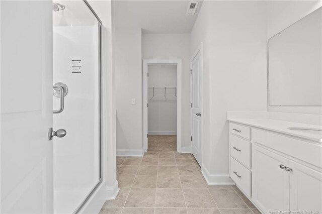 bathroom with tile patterned floors, vanity, and a shower with shower door