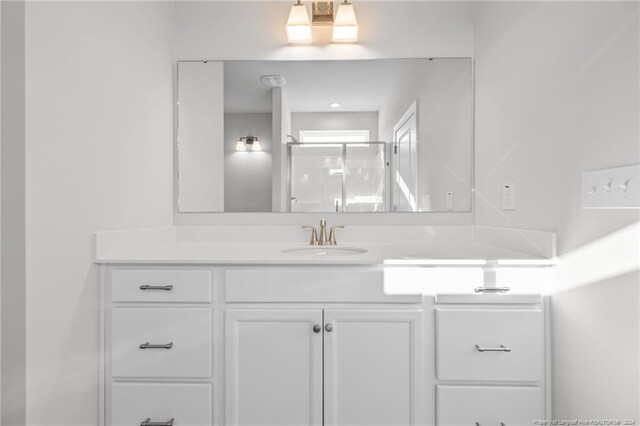 bathroom with vanity and a shower with shower door