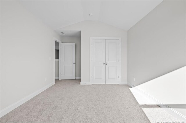 interior space with light colored carpet and vaulted ceiling