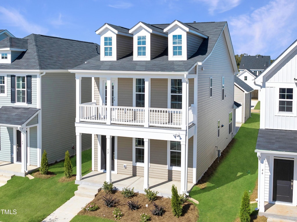 view of front facade featuring a front yard, a porch, and a balcony