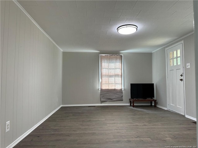unfurnished living room featuring baseboards, crown molding, and dark wood-style flooring