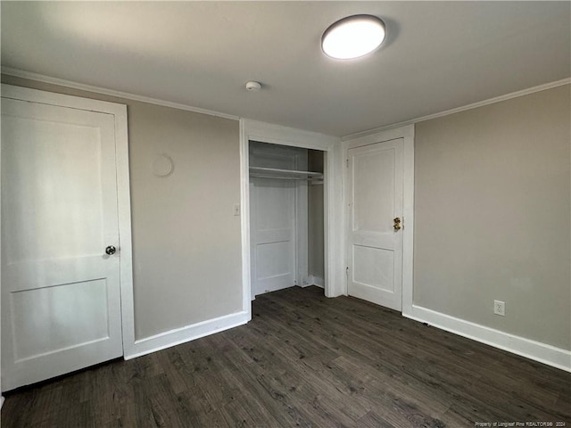 unfurnished bedroom with a closet, dark wood-type flooring, and baseboards