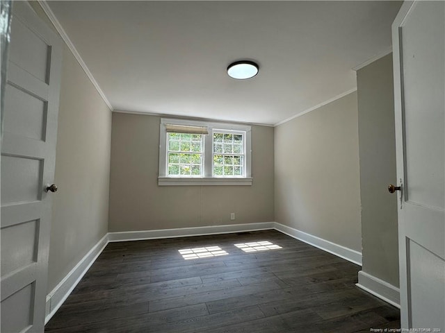 spare room with dark wood-type flooring, baseboards, and crown molding