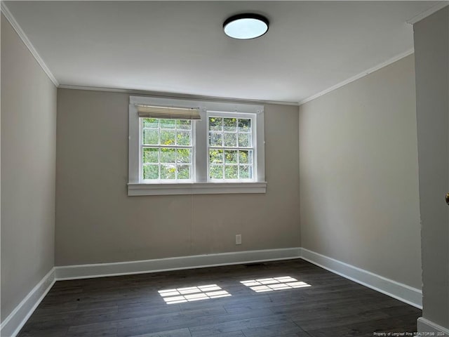 empty room featuring baseboards, ornamental molding, and wood finished floors
