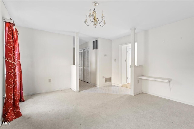 carpeted empty room featuring a notable chandelier