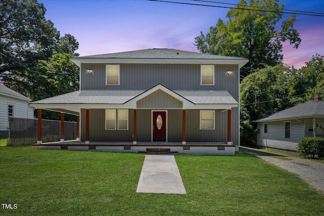 view of front of property featuring covered porch and a yard