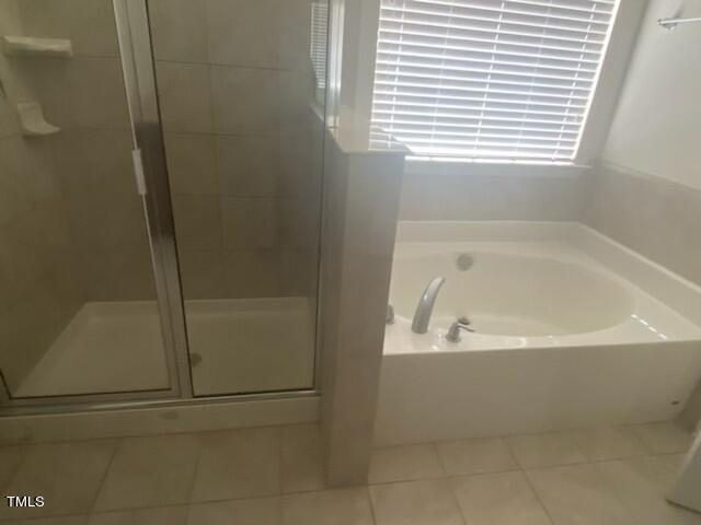 bathroom featuring tile patterned flooring and separate shower and tub