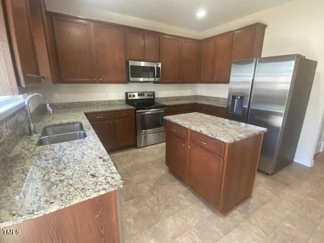 kitchen with light tile patterned floors, a center island, appliances with stainless steel finishes, and sink