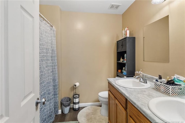 bathroom with vanity, hardwood / wood-style flooring, and toilet