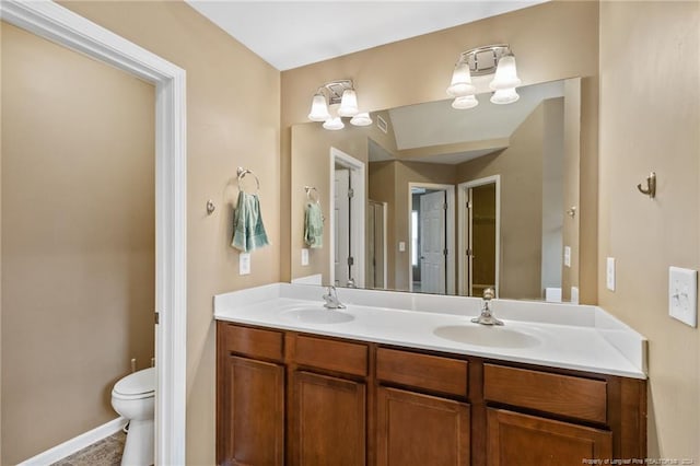 bathroom featuring a chandelier, vanity, and toilet