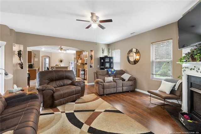 living room with dark hardwood / wood-style floors and ceiling fan