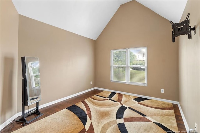 bedroom with baseboards, high vaulted ceiling, and wood finished floors